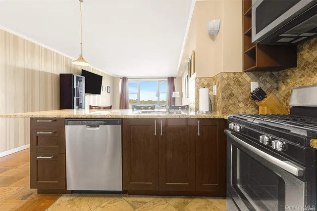 a kitchen with stainless steel appliances kitchen island granite countertop a stove a sink and a microwave