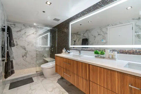 a spacious bathroom with a granite countertop sink mirror vanity and toilet