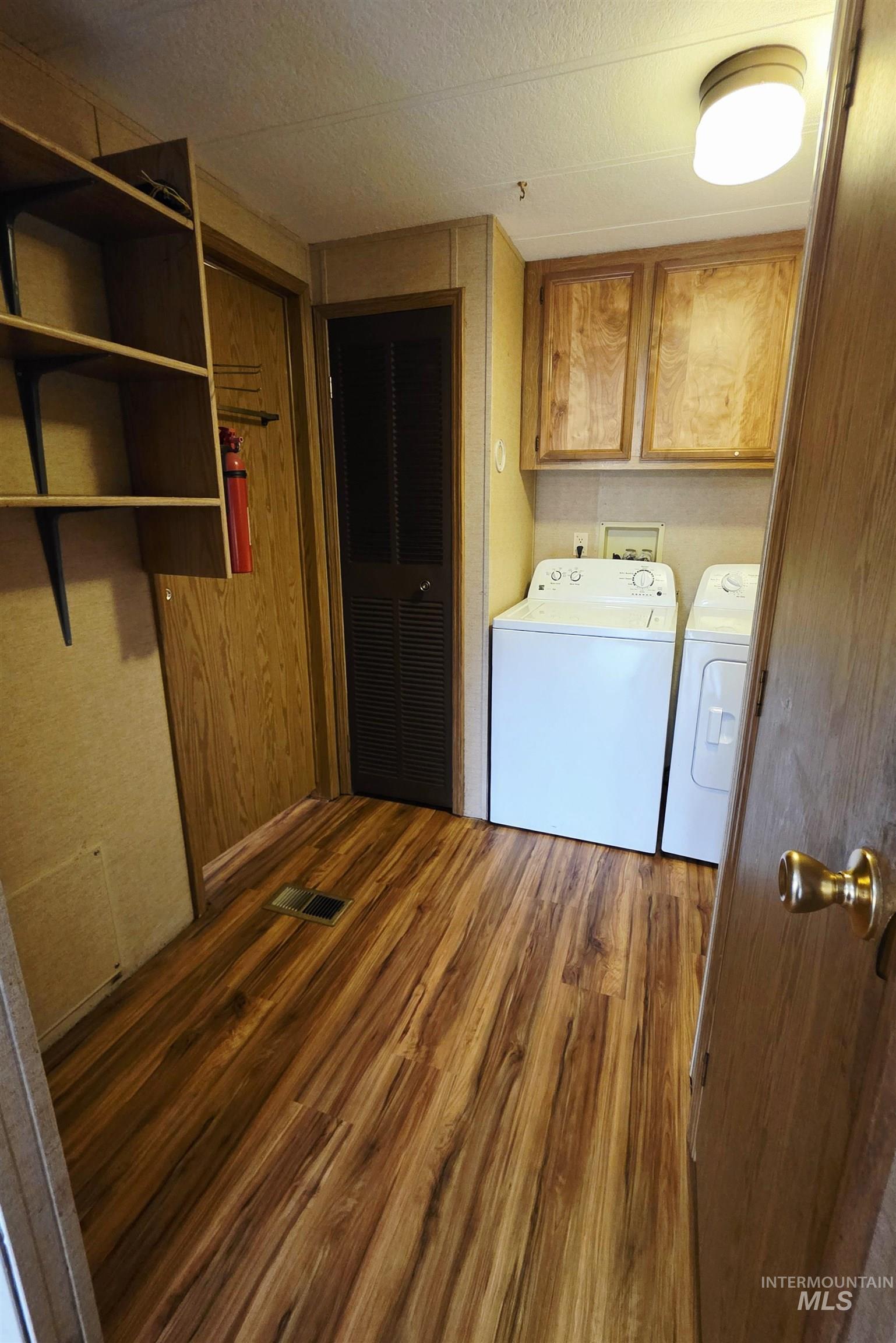 2015 6th Avenue, Unit 14 Clarkston, WA 99403 - Photo 12 of 27 Washroom featuring dark wood-style floors, cabinet space, and separate washer and dryer