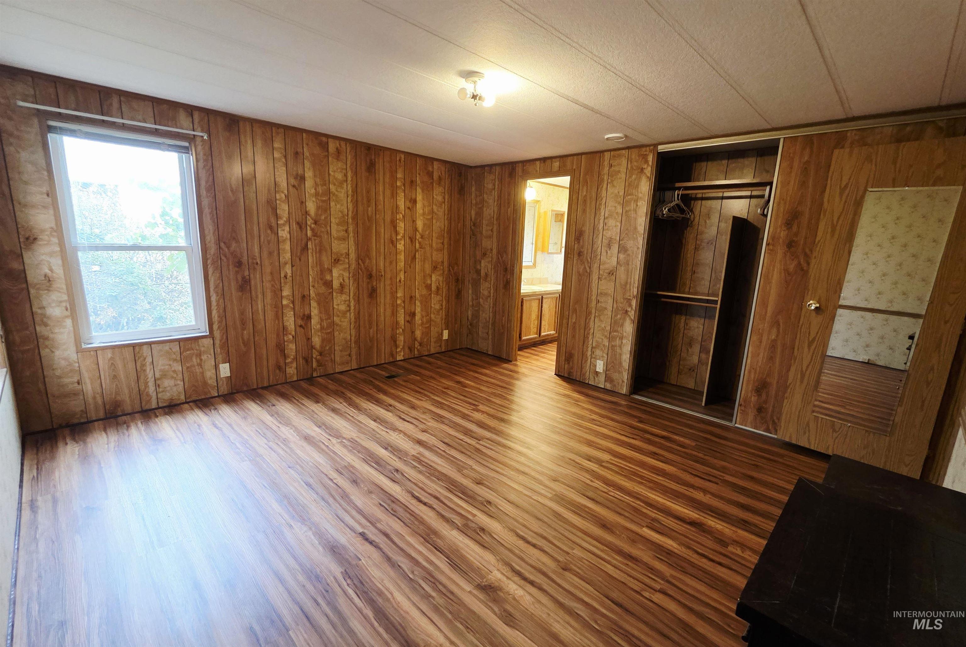 2015 6th Avenue, Unit 14 Clarkston, WA 99403 - Photo 16 of 27 Unfurnished bedroom with wood finished floors, a closet, wood walls, and ensuite bathroom