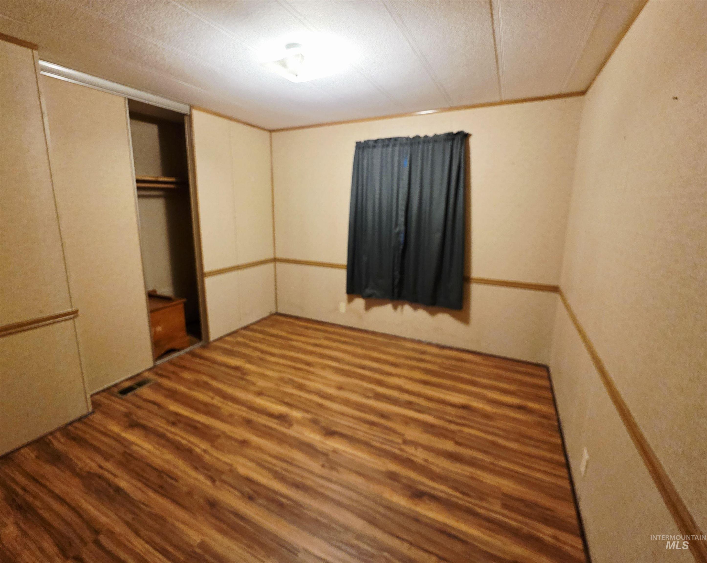 2015 6th Avenue, Unit 14 Clarkston, WA 99403 - Photo 22 of 27 Unfurnished bedroom featuring wood finished floors, a textured ceiling, a closet, and ornamental molding