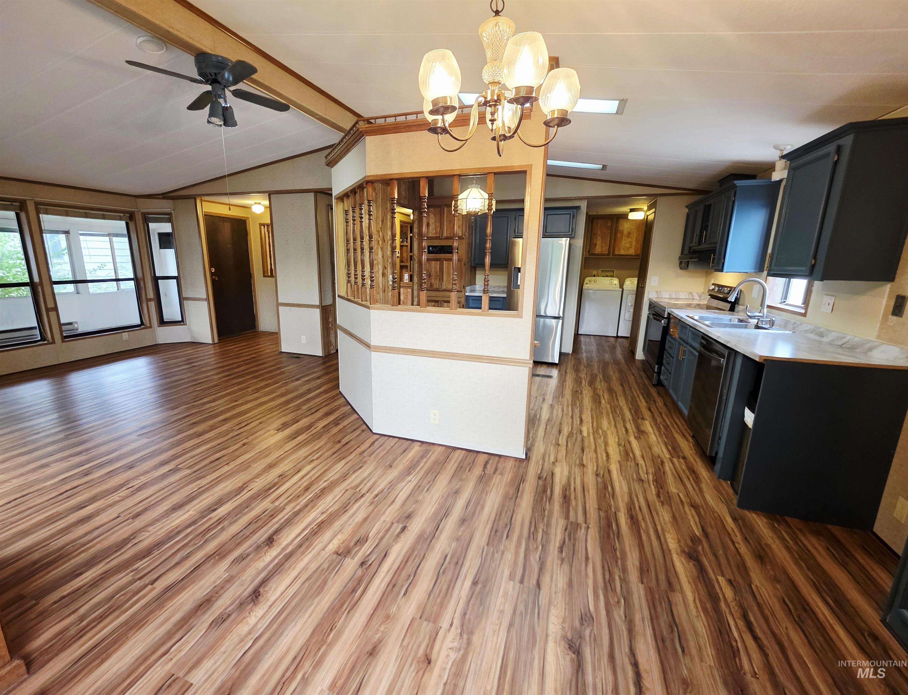 2015 6th Avenue, Unit 14 Clarkston, WA 99403 - Photo 27 of 27 Kitchen featuring dark cabinetry, light countertops, open floor plan, hanging light fixtures, and a chandelier