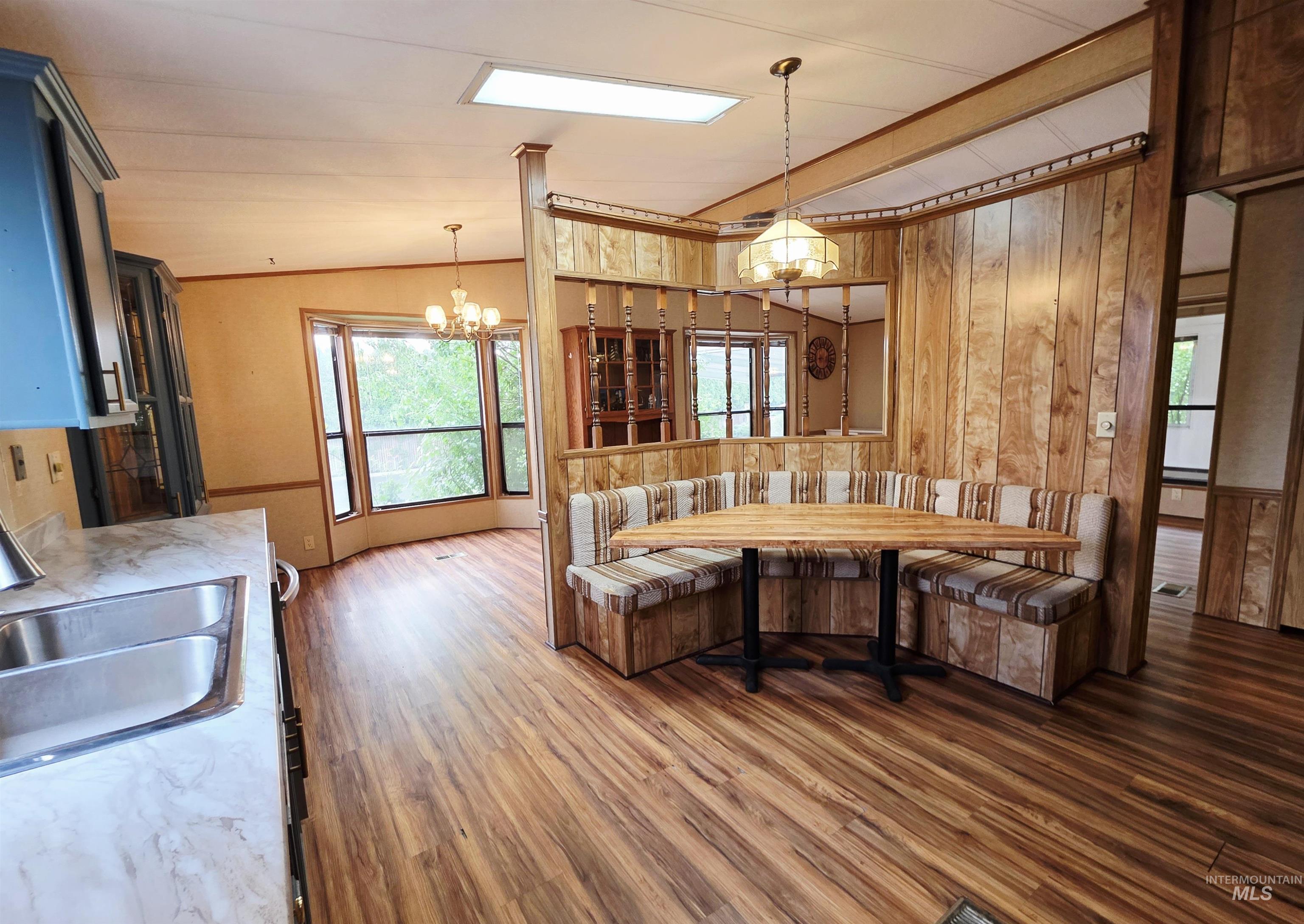 2015 6th Avenue, Unit 14 Clarkston, WA 99403 - Photo 7 of 27 Kitchen featuring wood finished floors, a chandelier, hanging light fixtures, wooden walls, and light countertops