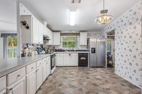 a kitchen with granite countertop a refrigerator and a sink