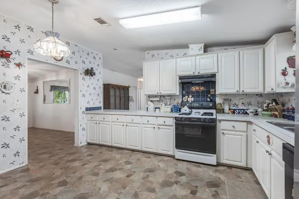 a kitchen with kitchen island granite countertop a sink window and cabinets