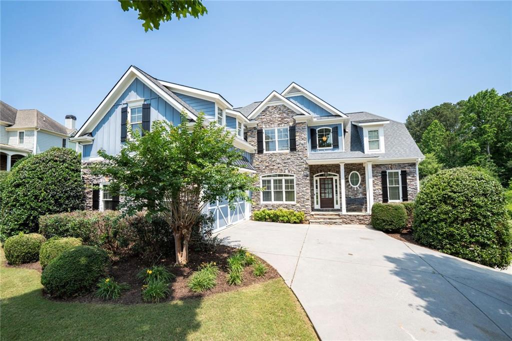 a front view of a house with a yard and potted plants