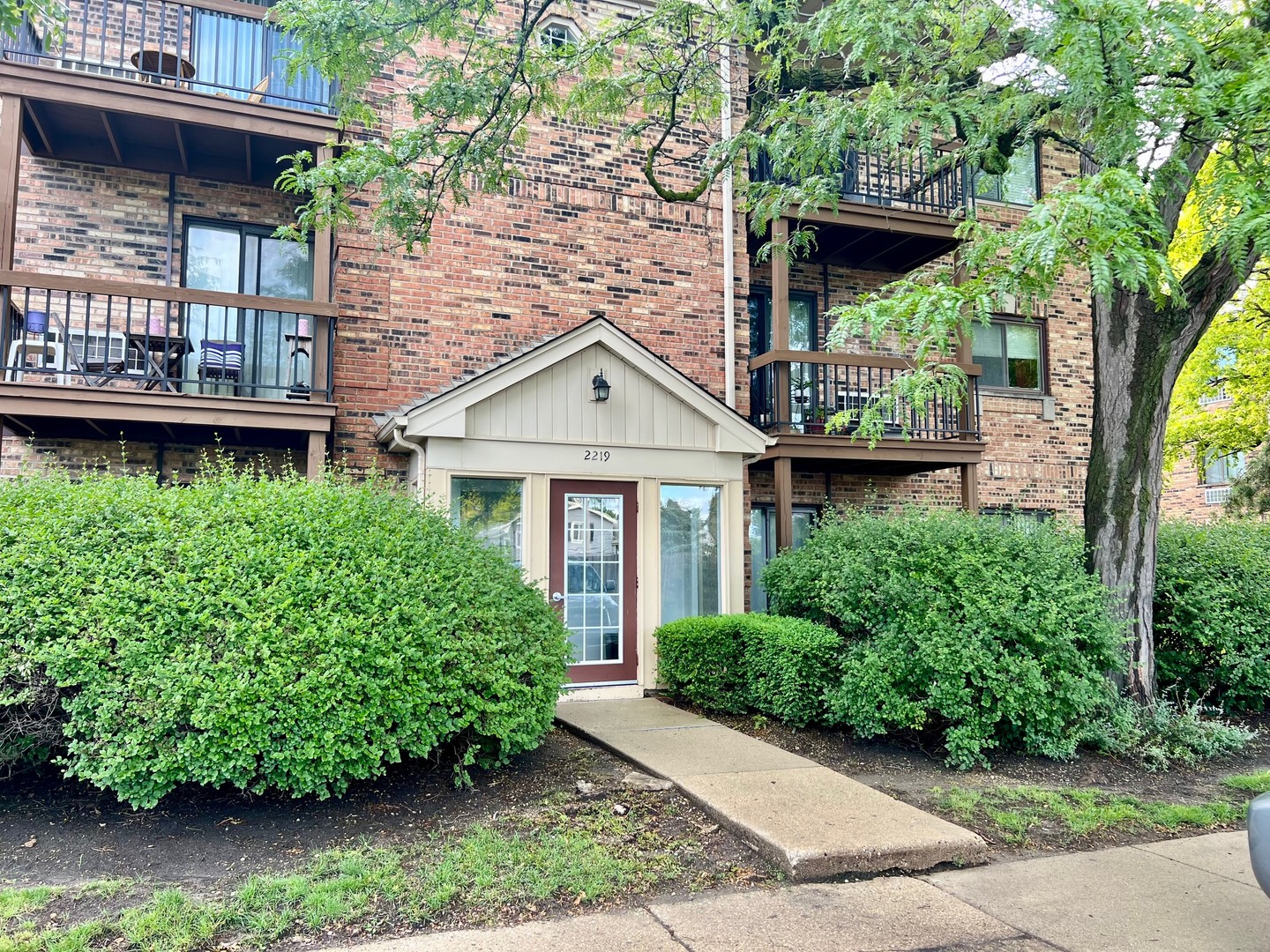 2219 Nichols Road, Unit 17A Arlington Heights, IL 60004 - Photo 1 of 19 a front view of a house with garden