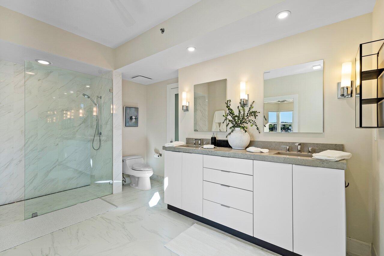 100 Mac Farlane Drive, Unit 2A Delray Beach, FL 33483 - Photo 17 of 28 a spacious bathroom with a shower sink and mirror
