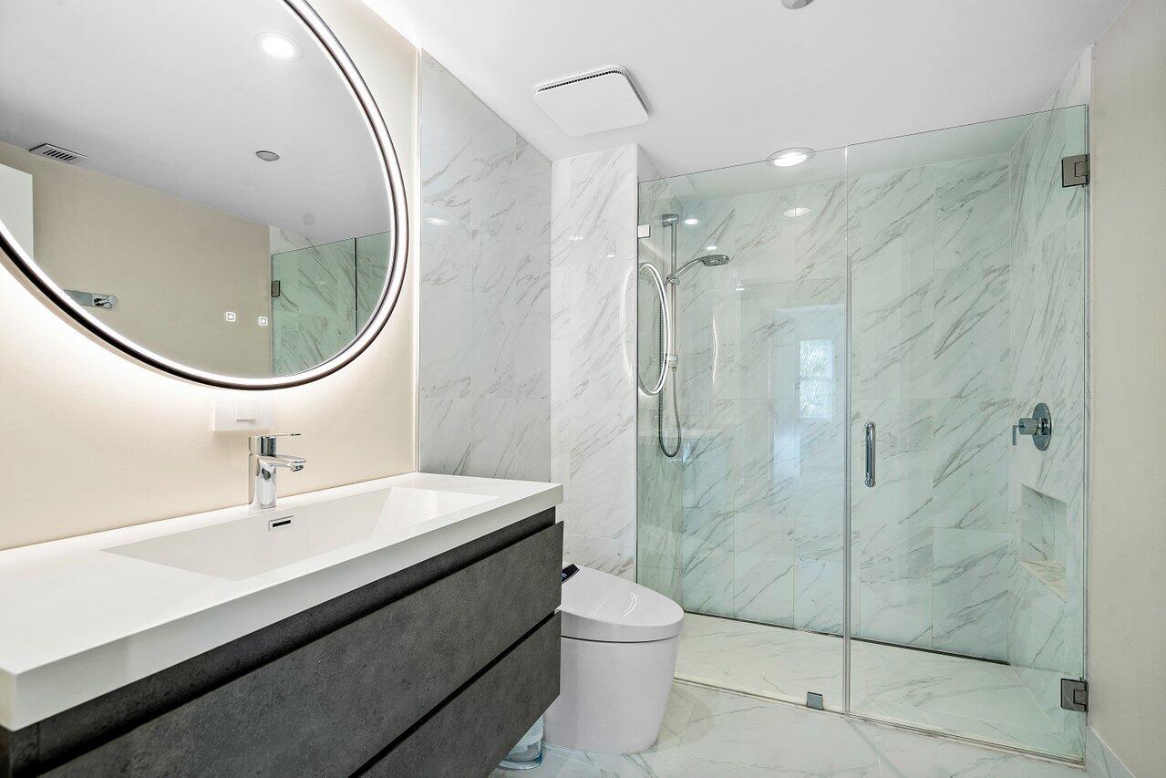 100 Mac Farlane Drive, Unit 2A Delray Beach, FL 33483 - Photo 22 of 28 a bathroom with a sink a toilet and shower