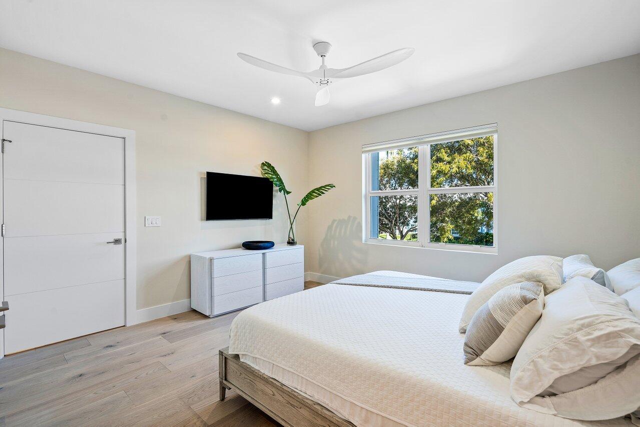 100 Mac Farlane Drive, Unit 2A Delray Beach, FL 33483 - Photo 23 of 28 a bedroom with a bed and a flat screen tv