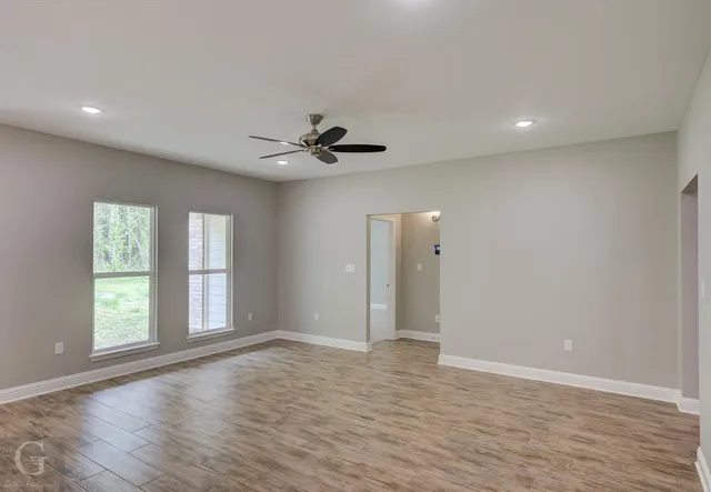 a open kitchen with white cabinets and wooden floor