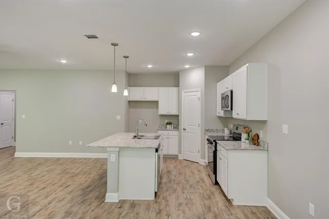 an empty room with windows and fan