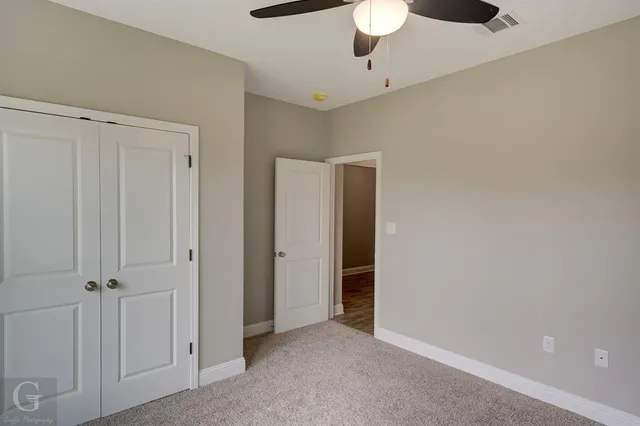 a bathroom with a granite countertop sink a toilet and tub