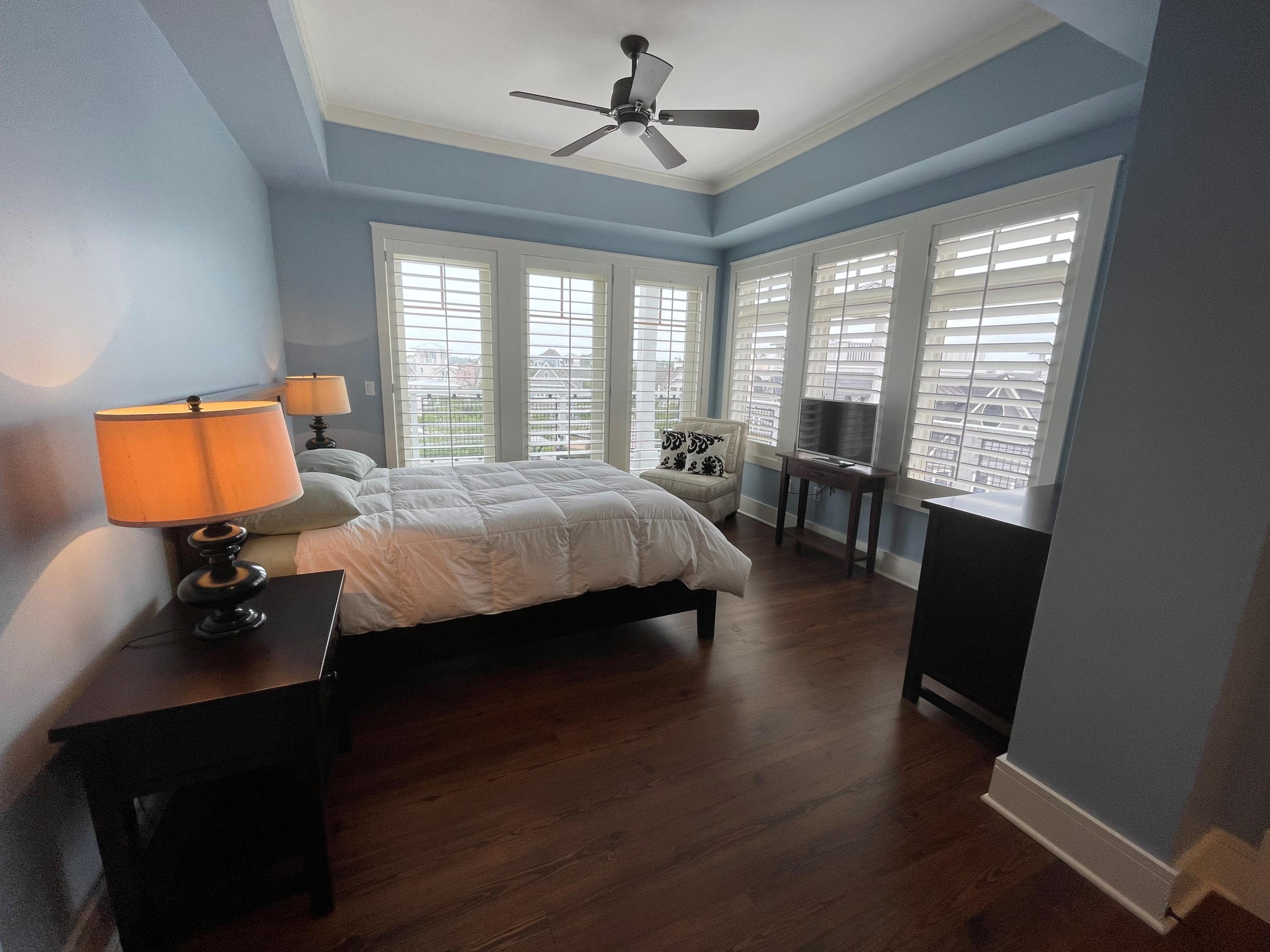 99 Compass Point Way South, Unit 402 Inlet Beach, FL 32461 - Photo 18 of 36 a bedroom with a bed a chair and a chandelier