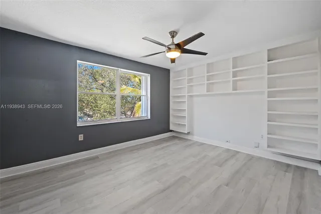an empty room with wooden floor and entryway