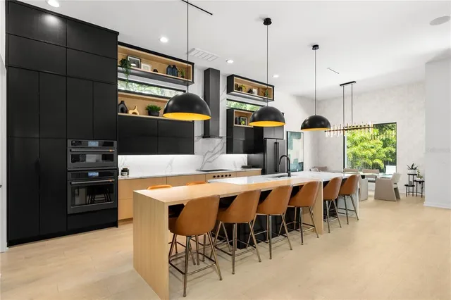 a kitchen with stainless steel appliances a stove refrigerator and a view of living room