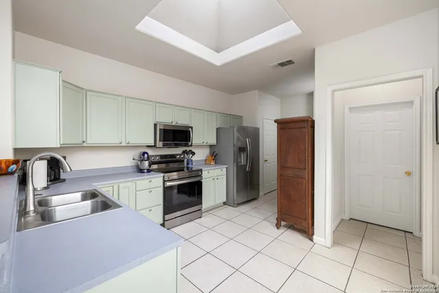 a kitchen with granite countertop a refrigerator and a stove top oven