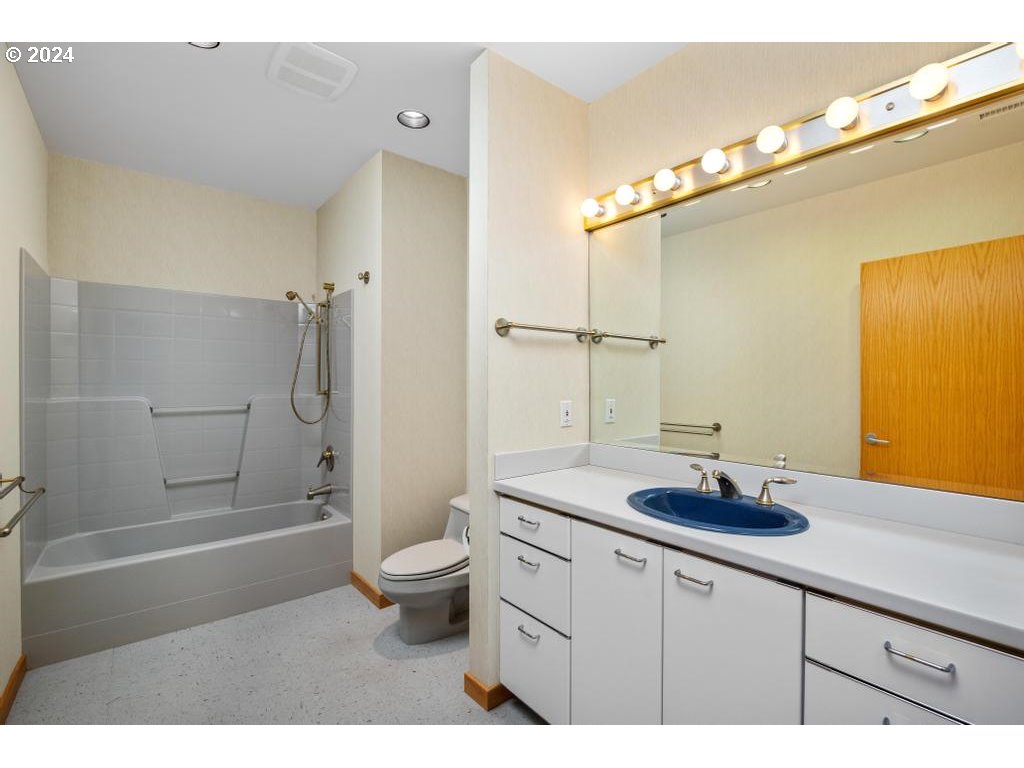 2020 Southwest Market St Drive, Unit 101 Portland, OR 97201 - Photo 27 of 33 a bathroom with a granite countertop sink a toilet a mirror and shower