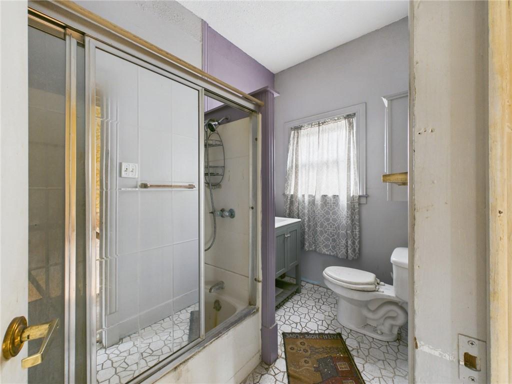 3698 Frew Mill Road New Castle, PA 16101 - Photo 17 of 25 a bathroom with a granite countertop sink a toilet and shower