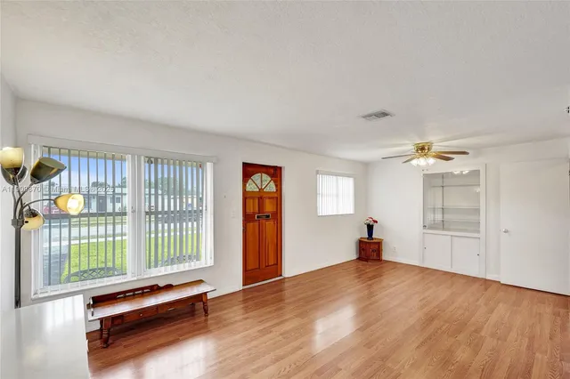 a white kitchen with stainless steel appliances granite countertop a stove and a refrigerator
