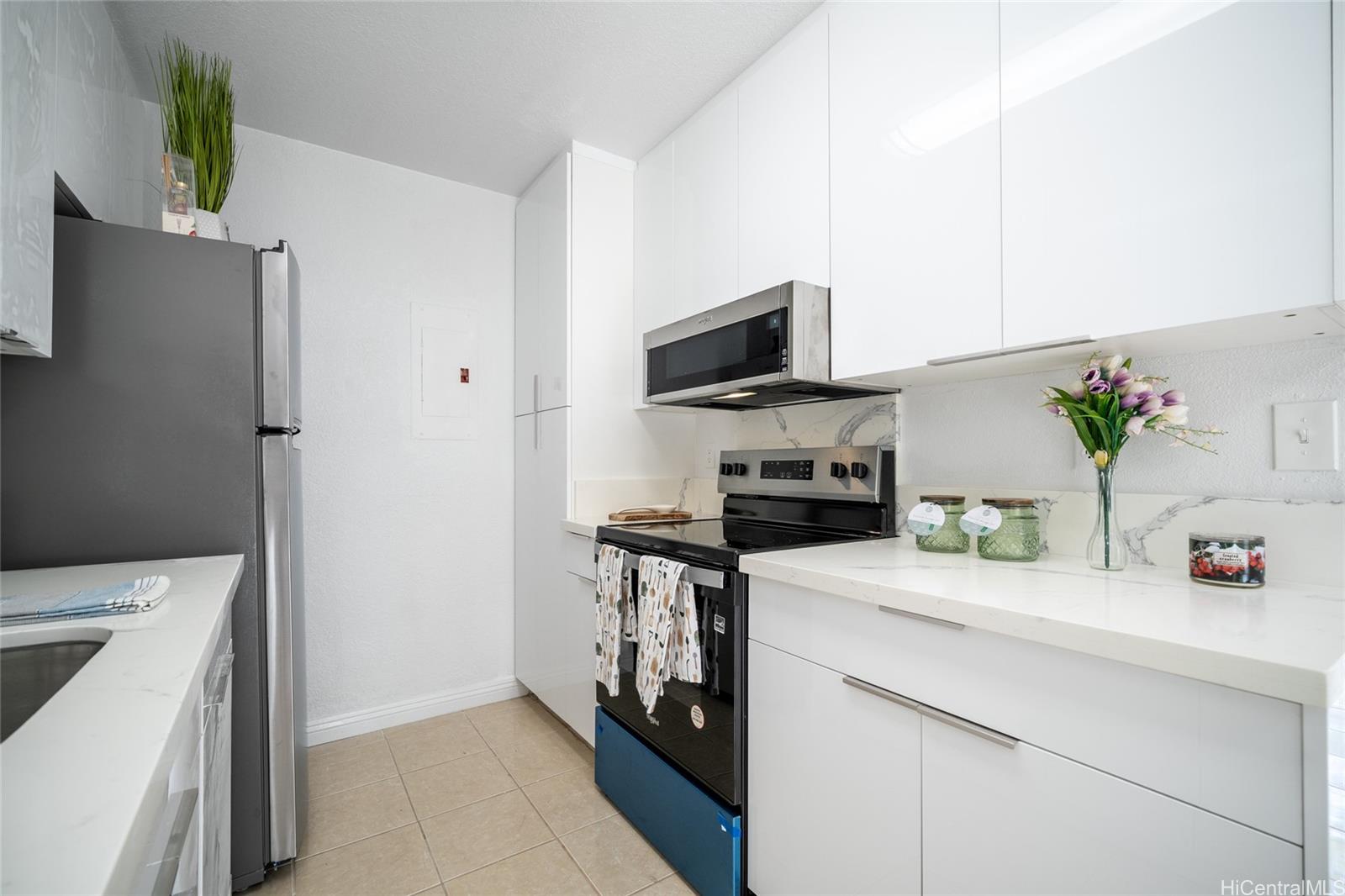 625 Mananai Place, Unit 24A Honolulu, HI 96818 - Photo 1 of 18 a kitchen with a sink a stove and a refrigerator