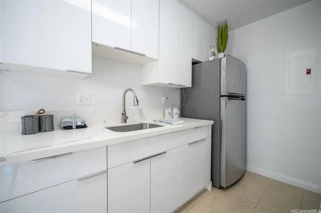 a kitchen with a sink a refrigerator and cabinets