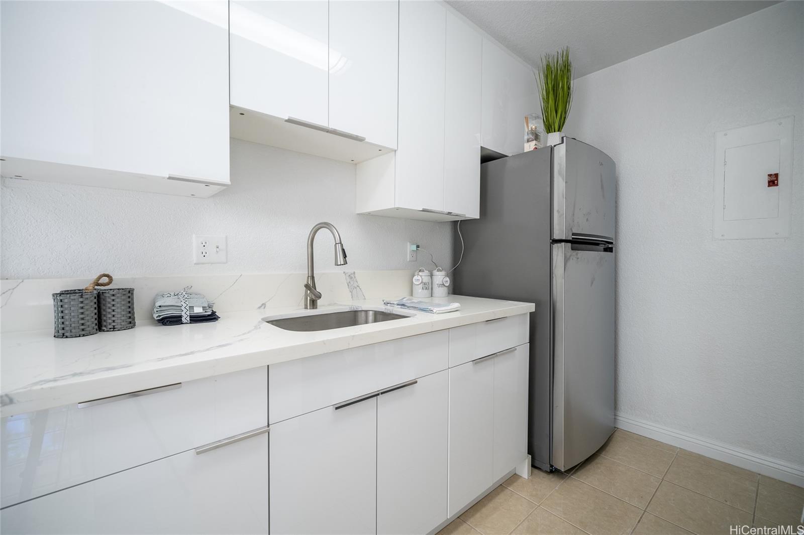 625 Mananai Place, Unit 24A Honolulu, HI 96818 - Photo 2 of 18 a kitchen with a sink a refrigerator and cabinets
