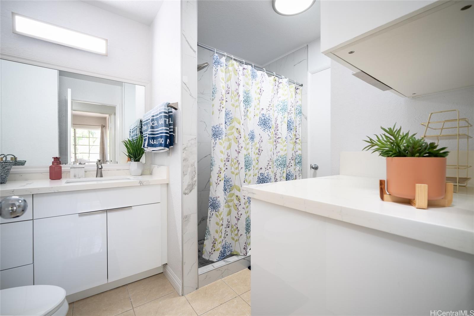 625 Mananai Place, Unit 24A Honolulu, HI 96818 - Photo 9 of 18 a bathroom with a granite countertop sink and a mirror