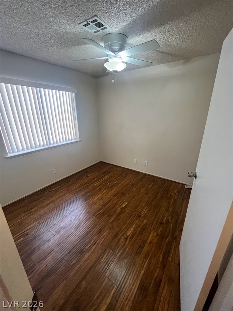 914 Scarlet Ridge Drive Las Vegas, NV 89128 - Photo 21 of 25 Rich hardwood floors complement neutral walls in this tranquil sleeping area, illuminated by natural light.