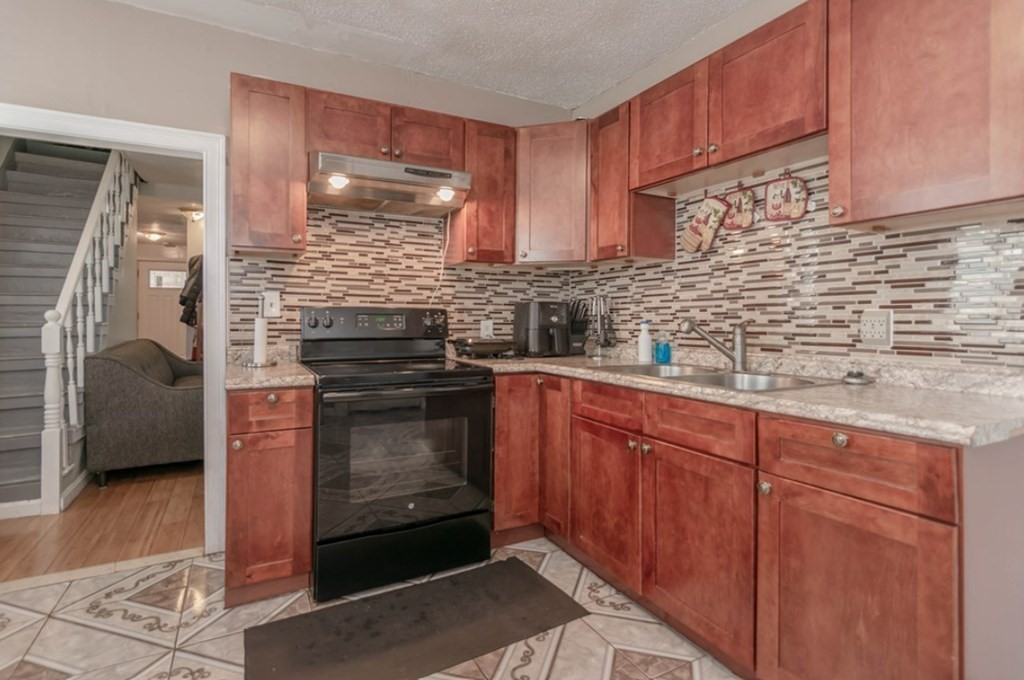 58 Lake Street Lawrence, MA 01841 - Photo 11 of 26 a kitchen with stainless steel appliances granite countertop a stove and a sink