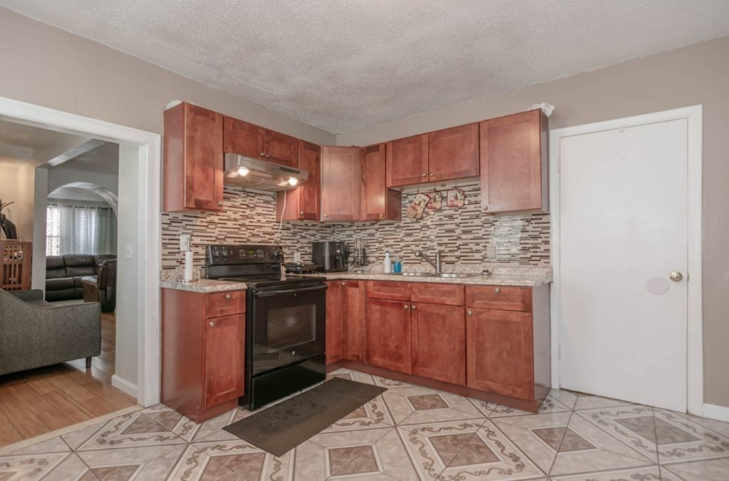 58 Lake Street Lawrence, MA 01841 - Photo 12 of 26 a kitchen with stainless steel appliances granite countertop a stove sink and cabinets