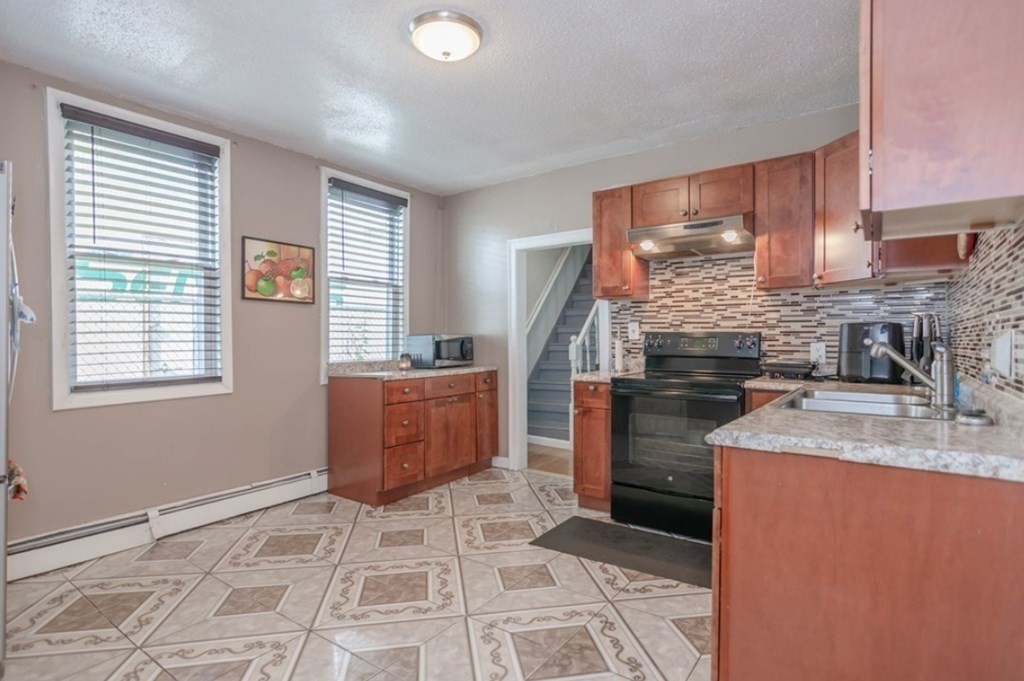 58 Lake Street Lawrence, MA 01841 - Photo 13 of 26 a kitchen with a stove a sink and a refrigerator