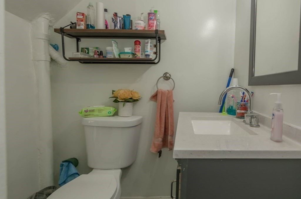 58 Lake Street Lawrence, MA 01841 - Photo 18 of 26 a bathroom with a toilet a sink and a mirror