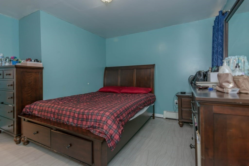 58 Lake Street Lawrence, MA 01841 - Photo 20 of 26 a bed sitting in a bedroom next to a dresser with a wooden floor