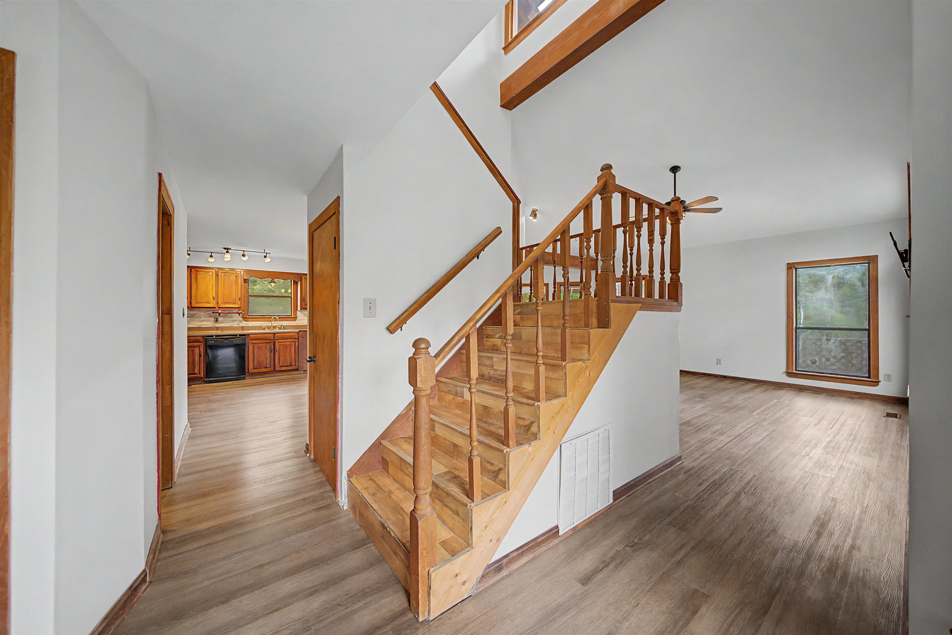 2380 Dunaway Road Selmer, TN 38375 - Photo 15 of 39 Two-story entry featuring wood staircase with matching railing, wood-finish flooring, and high ceilings with exposed wood beams