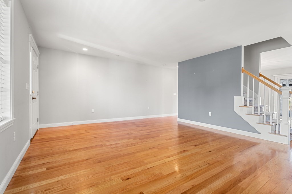 8 Comanche Circle, Unit 4 Haverhill, MA 01835 - Photo 14 of 19 a view of an empty room with wooden floor and stairs