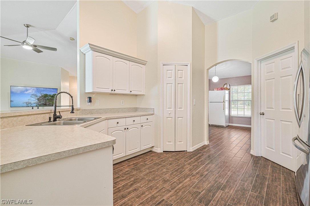 200 Roat Street Lehigh Acres, FL 33936 - Photo 15 of 35 a kitchen with white cabinets and wooden floor