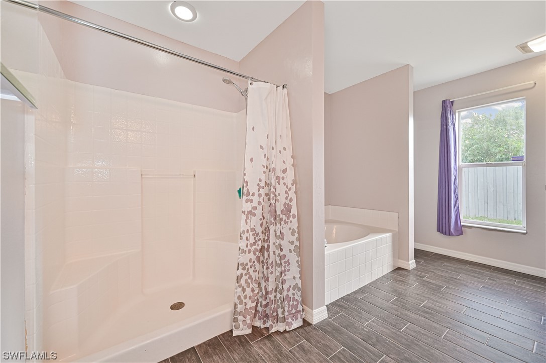 200 Roat Street Lehigh Acres, FL 33936 - Photo 20 of 35 a bathroom with a bathtub a window and a shower