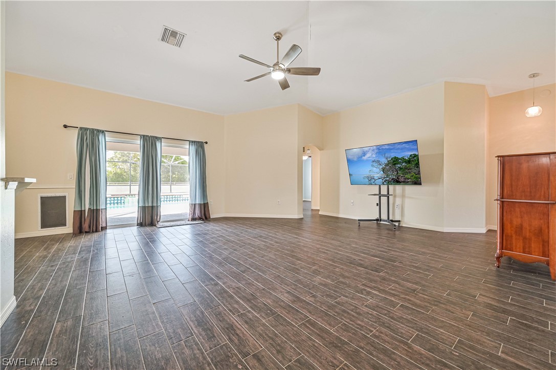 200 Roat Street Lehigh Acres, FL 33936 - Photo 8 of 35 a view of a livingroom with wooden floor a ceiling fan and windows