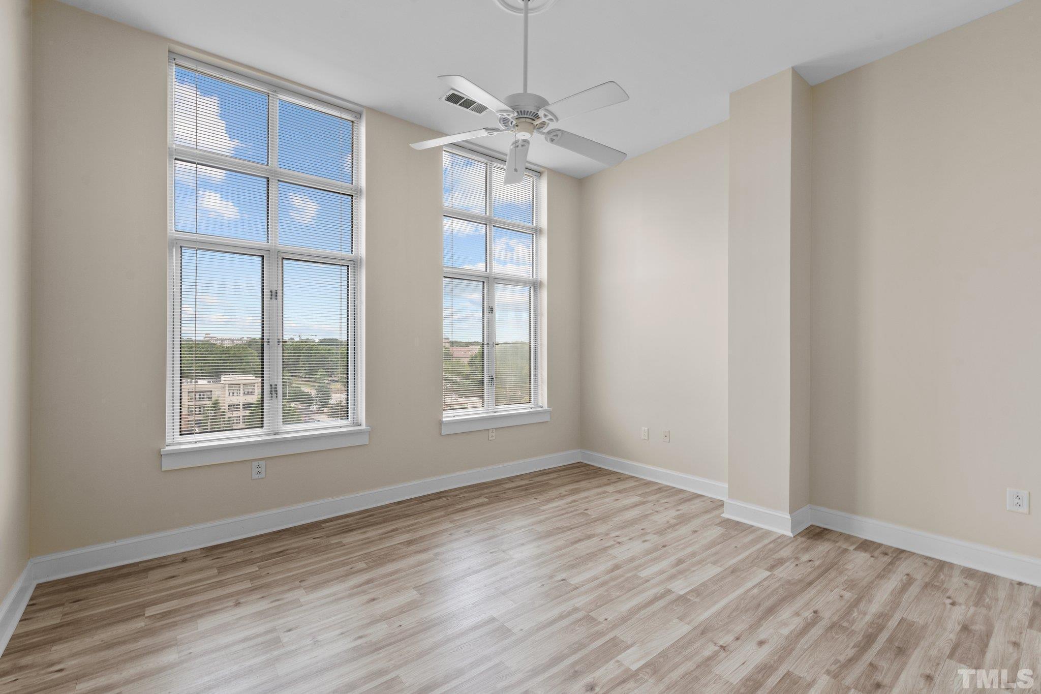 618 North Boylan Avenue, Unit 1032 Raleigh, NC 27603 - Photo 14 of 69 an empty room with wooden floor chandelier fan and windows