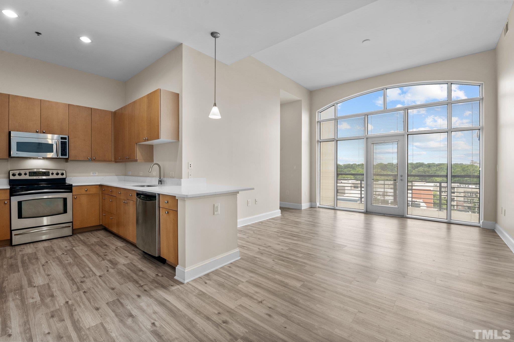 618 North Boylan Avenue, Unit 1032 Raleigh, NC 27603 - Photo 3 of 69 a kitchen with stainless steel appliances a stove top oven a sink a refrigerator with wooden floors and cabinets