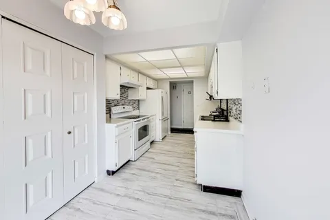 a kitchen with cabinets and wooden floor