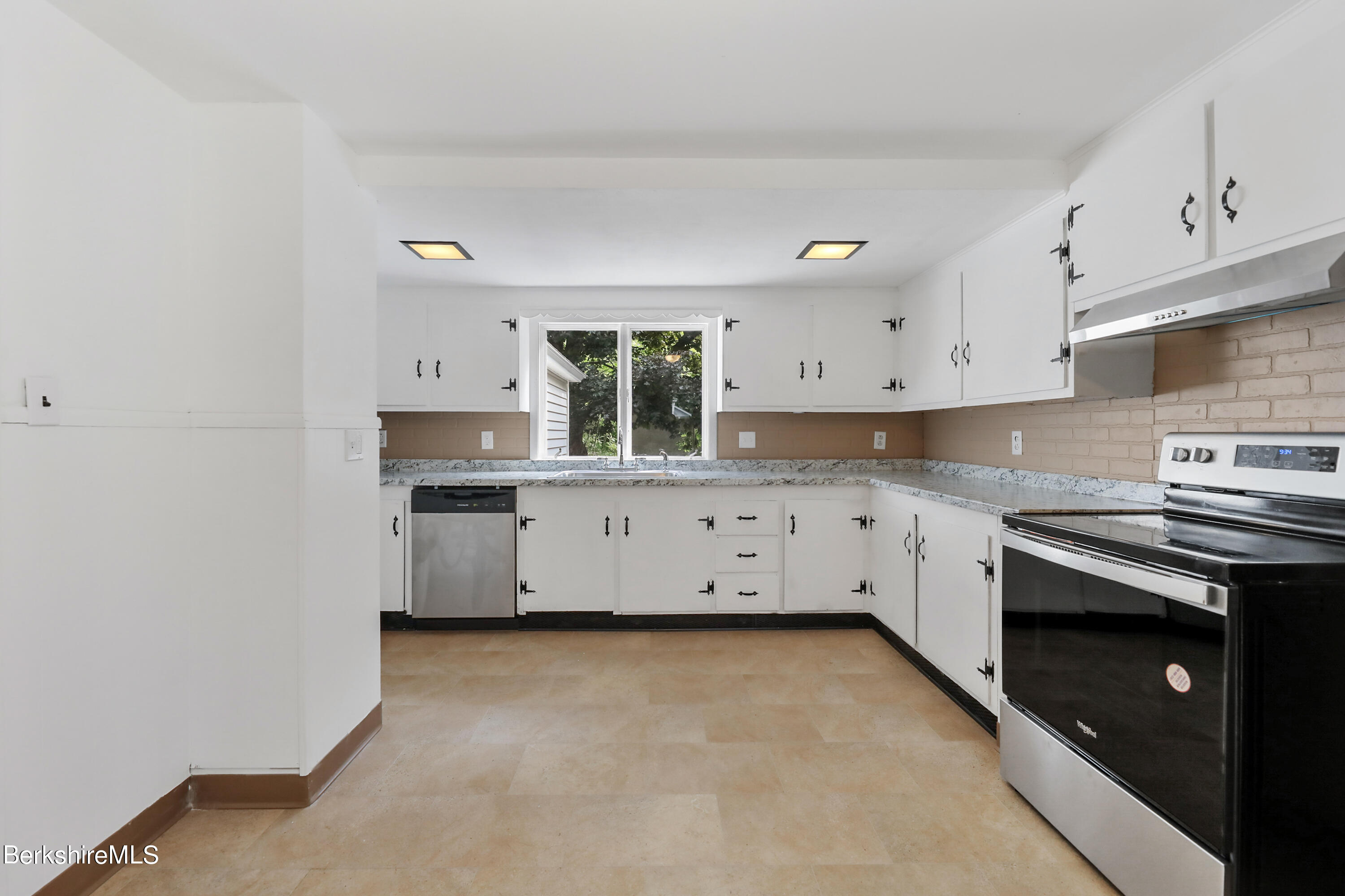 99 Lyman Street Pittsfield, MA 01201 - Photo 13 of 38 a kitchen with stainless steel appliances a stove a sink cabinets and a refrigerator
