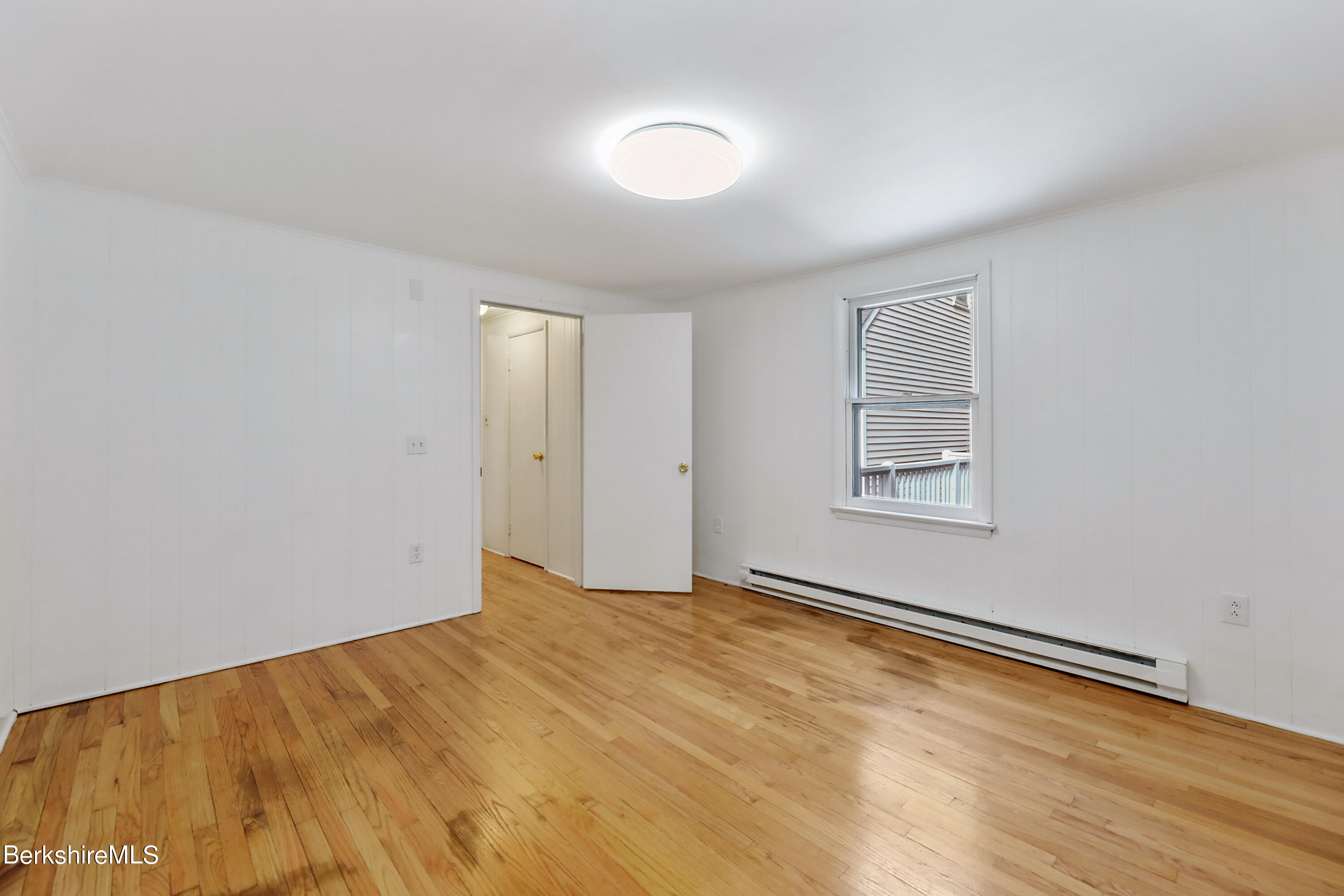 99 Lyman Street Pittsfield, MA 01201 - Photo 18 of 38 a view of an empty room with wooden floor and a window