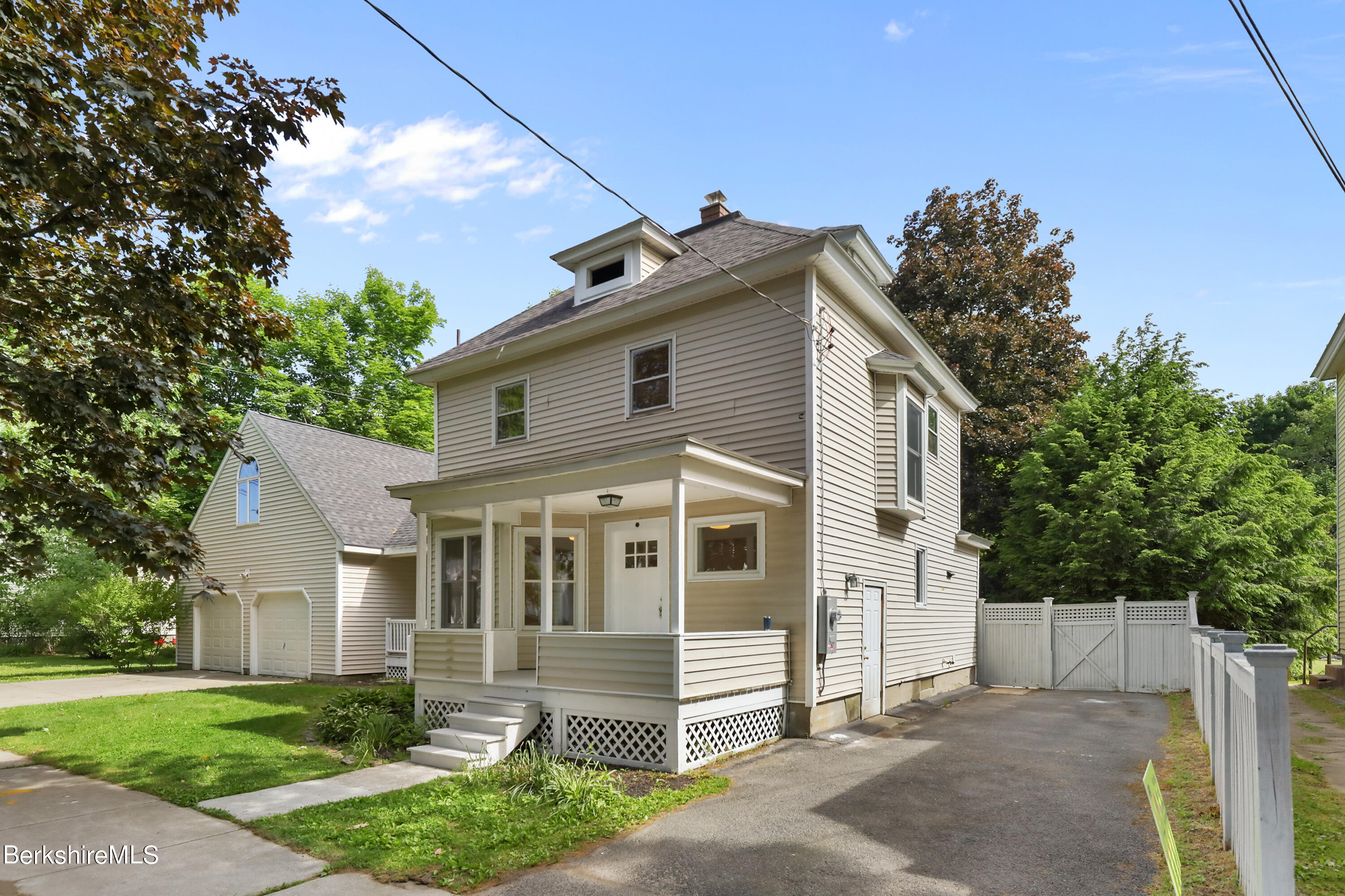 99 Lyman Street Pittsfield, MA 01201 - Photo 2 of 38 a front view of a house with a garden
