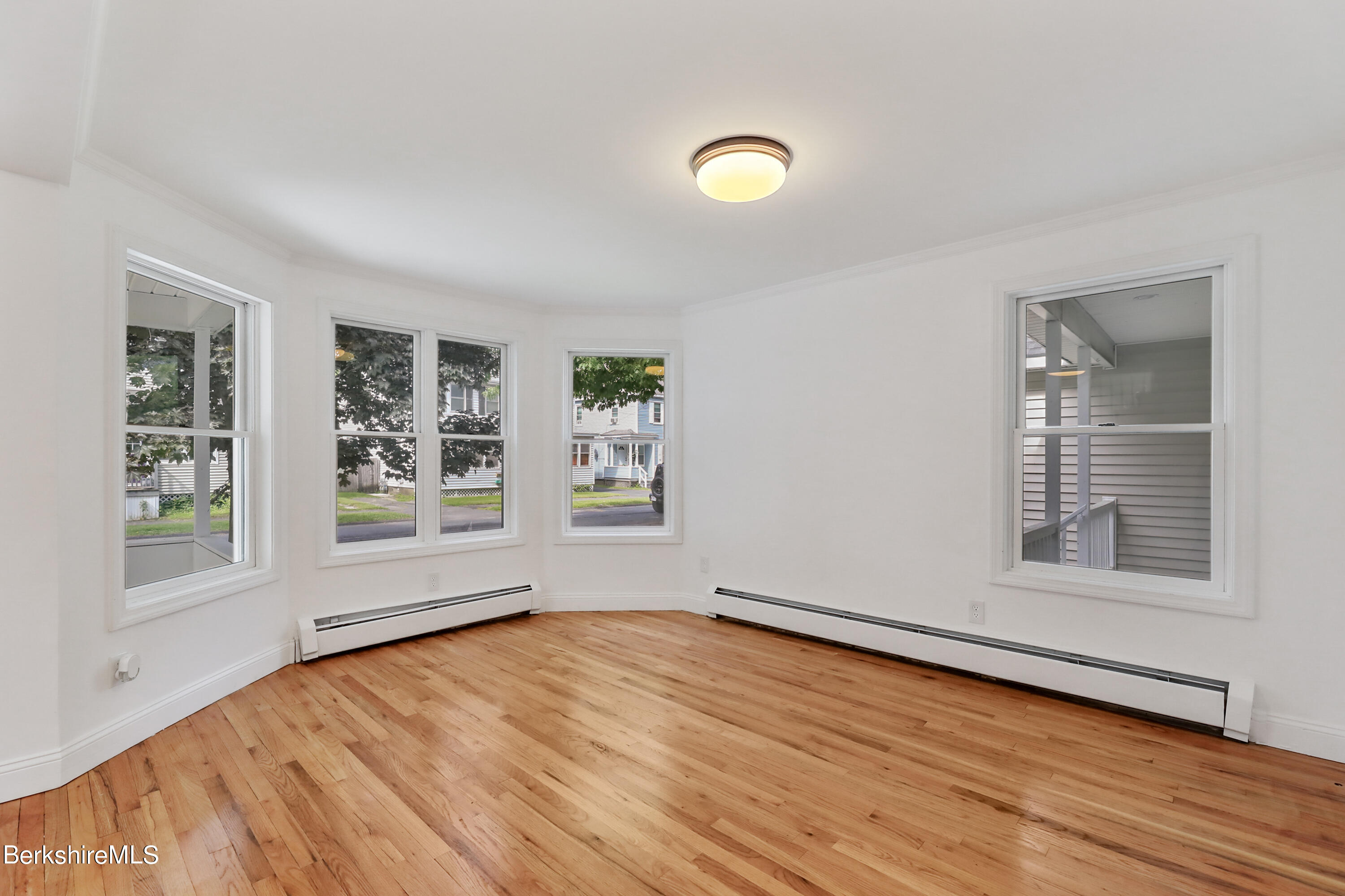 99 Lyman Street Pittsfield, MA 01201 - Photo 6 of 38 a view of empty room with wooden floor and fan