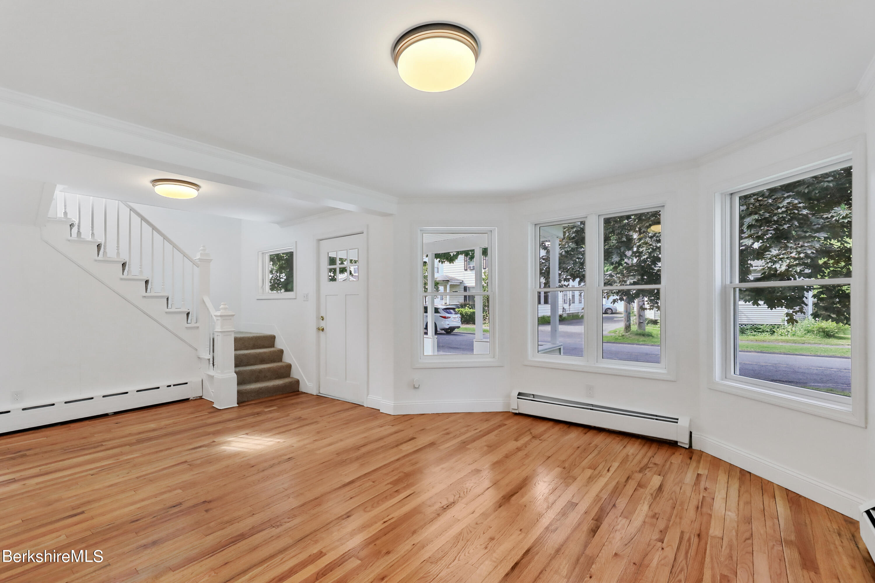99 Lyman Street Pittsfield, MA 01201 - Photo 8 of 38 an empty room with wooden floor and windows