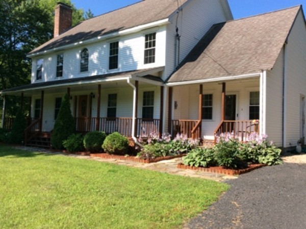 1376 Patrill Hollow Road Hardwick, MA 01082 - Photo 16 of 16 a view of a brick house with many windows plants and large tree