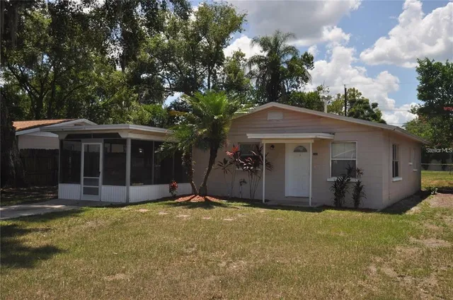 a view of a house with a yard and tree