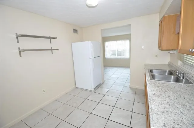 a view of a kitchen with a sink and a refrigerator